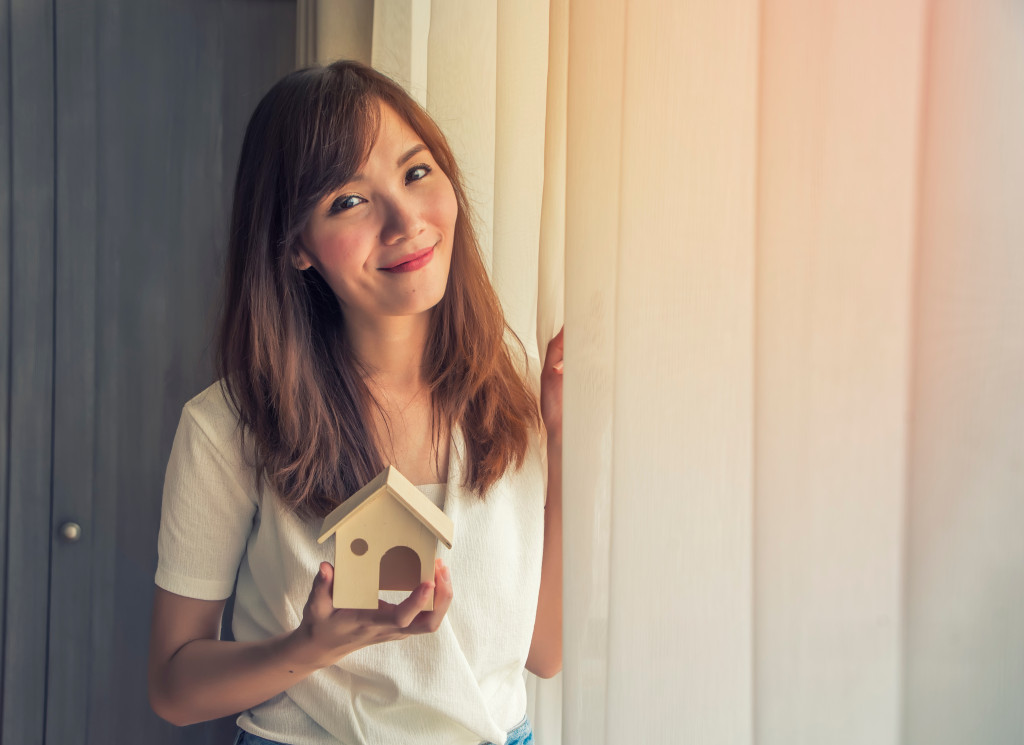 woman holding a mini house model