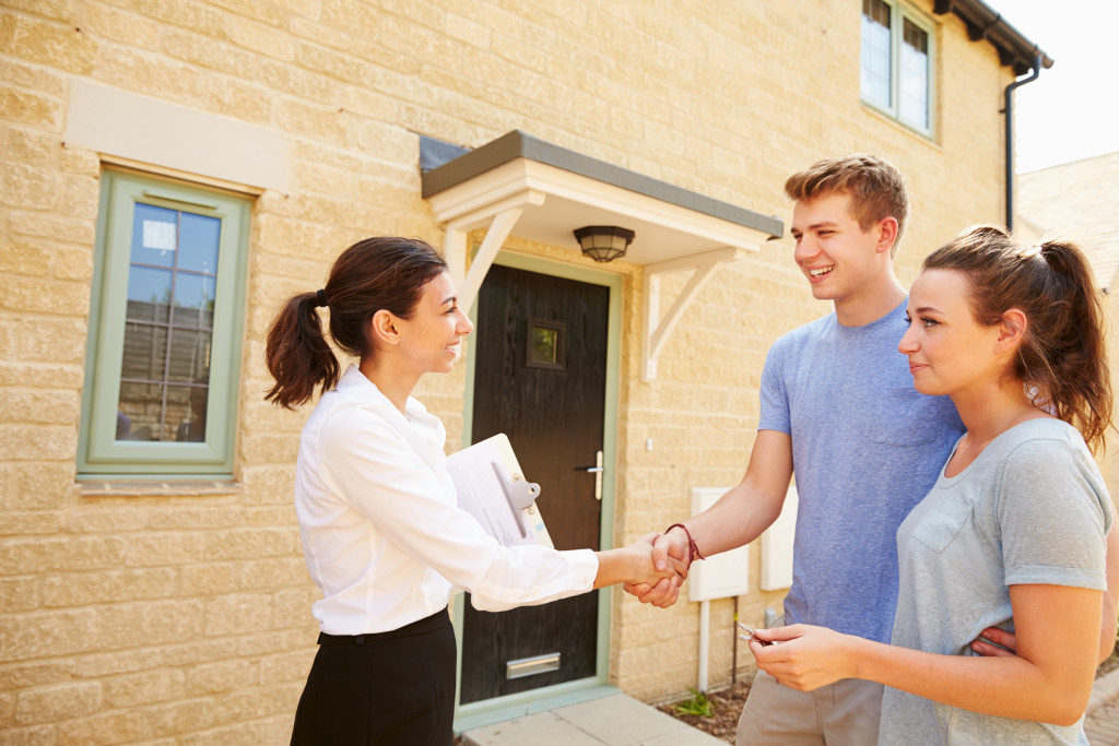 A landlord shaking hands with a tenant couple