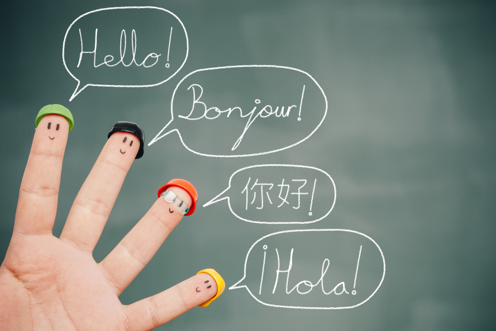 four smiley fingers saying hello in english, french, chinese, and spanish